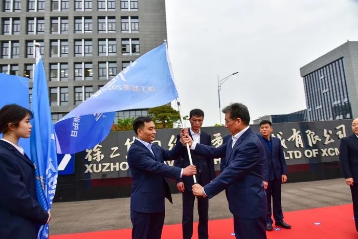 半岛平台起重机械事业部副总经理史先信向半岛平台重型服务备件中心总经理姜凡科、半岛平台履带客户服务中心总经理郝敏、半岛平台塔机营销公司副总经理吴建明以及供应商、经销商代表授旗